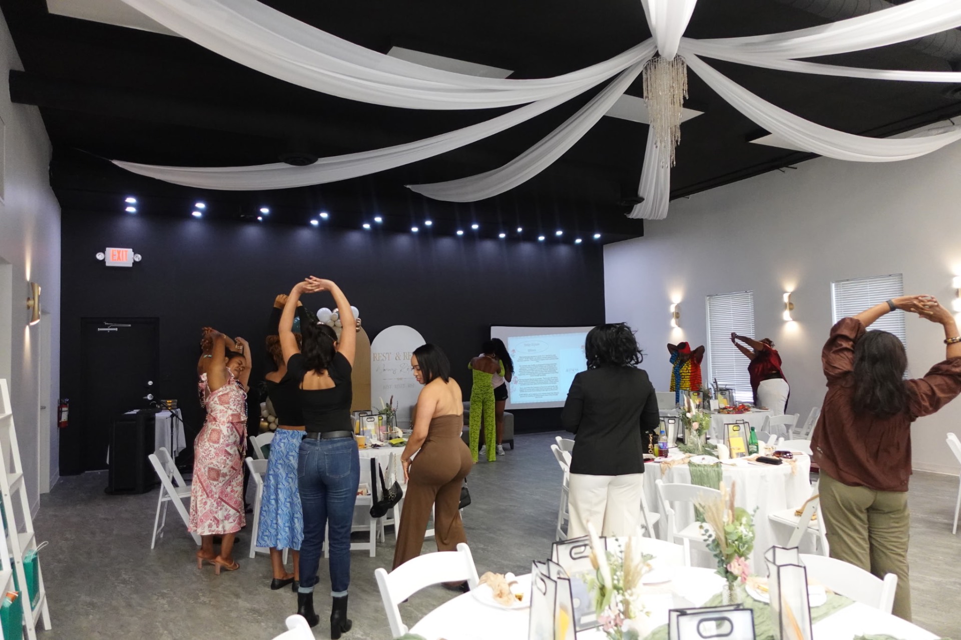 Guests moving through a guided stretch under draped ceilings