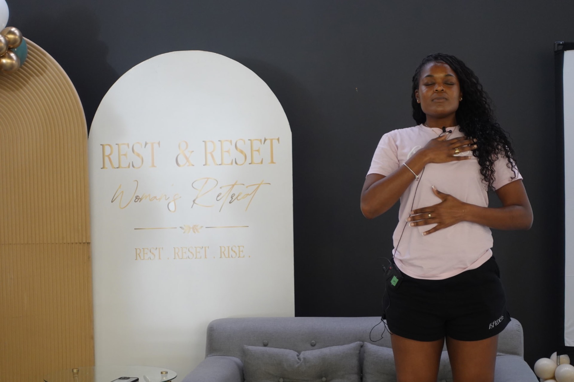 Facilitator leading a breathing exercise beside the Rest & Reset backdrop