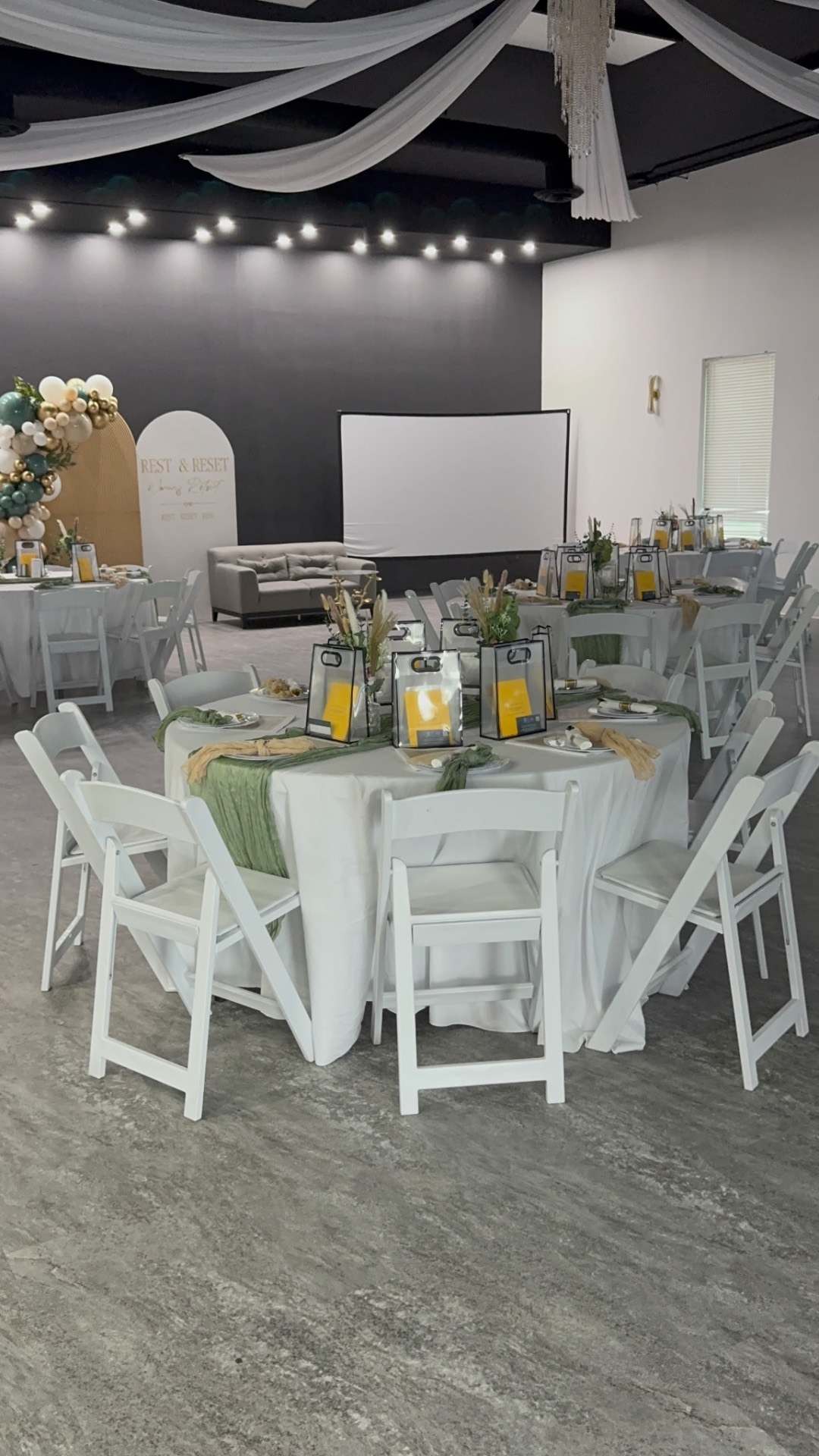 Round tables dressed in white and sage linen at the women's retreat
