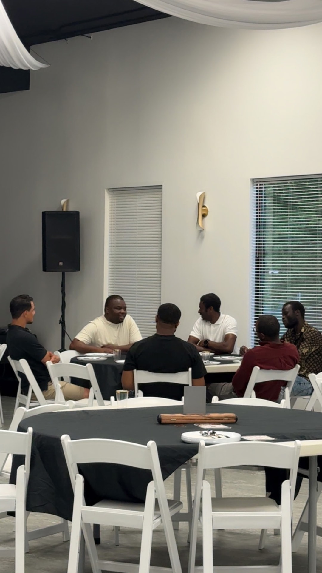 Men seated around a table in conversation at Men's Lounge Night